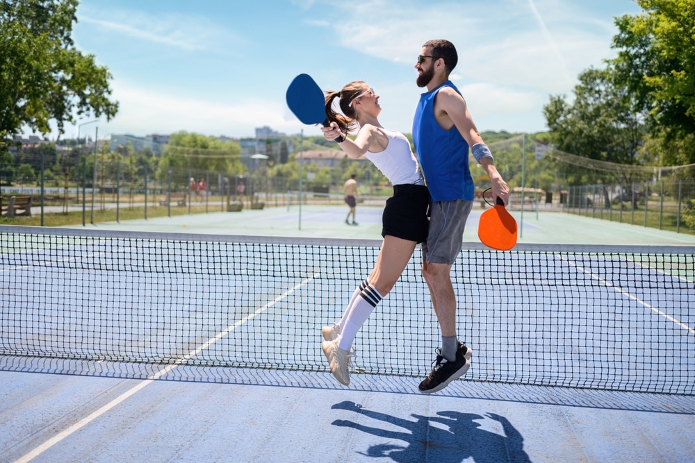 A view of a couple celebrating pickleball win in a court