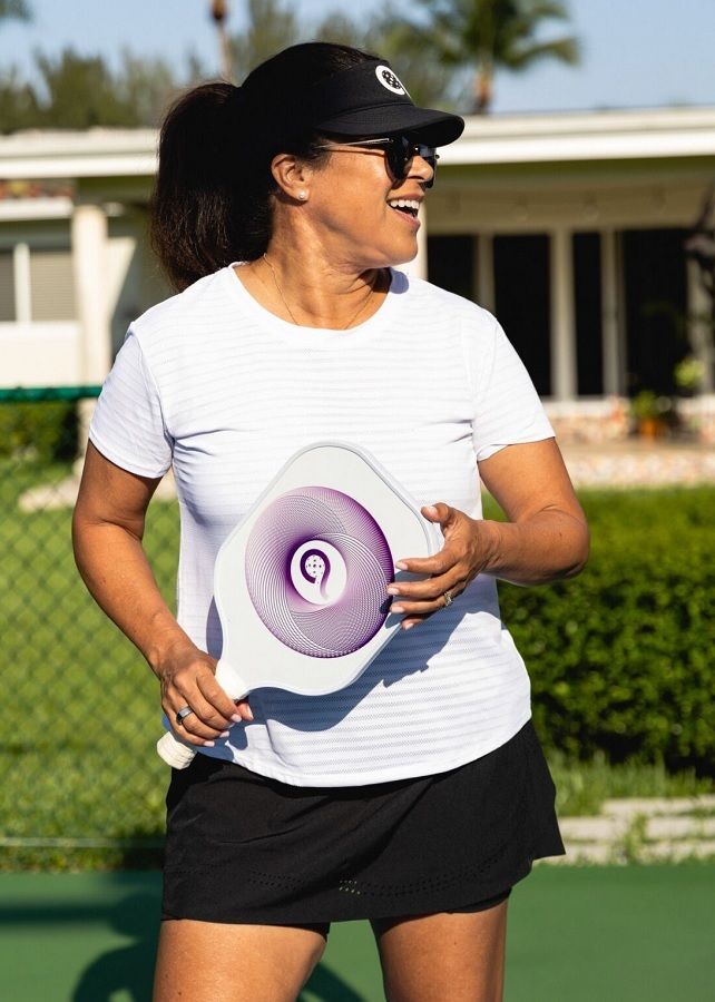 a women wearing shorts and shirt while having pickleball paddle in her hand