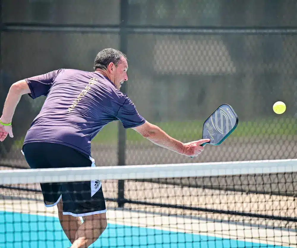 A guy hitting an erne shot with a paddle