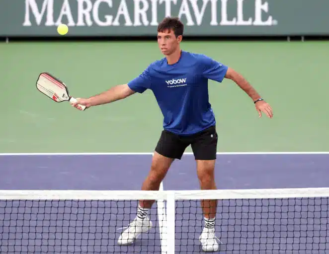 A view of a guy hitting a pickleball