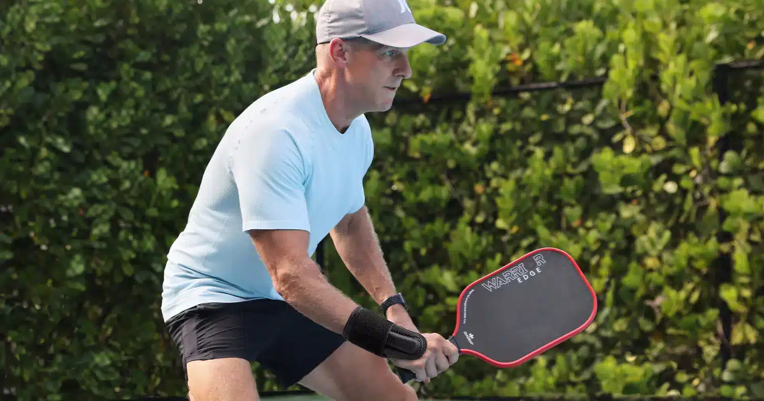 A view of a guy holding a paddle and waiting for his turn