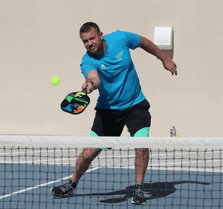 A view of a guy using a rd shot drop in pickleball