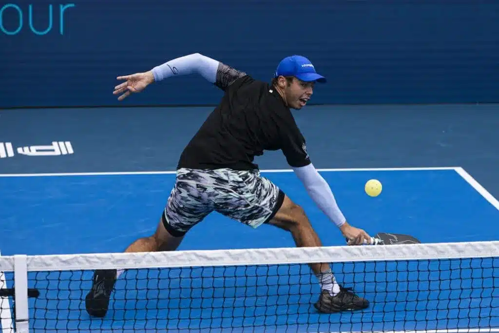 A view of a person hitting the around the post shot in pickleball