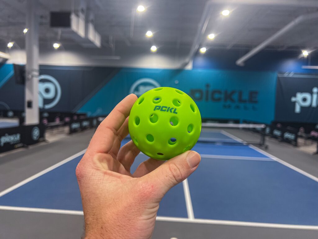 A view of a person holding a green pickleball