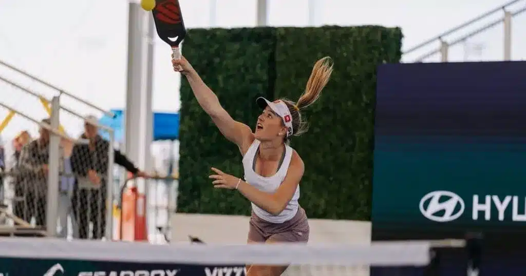 A view of a woman hitting an overhead shot in pickleball