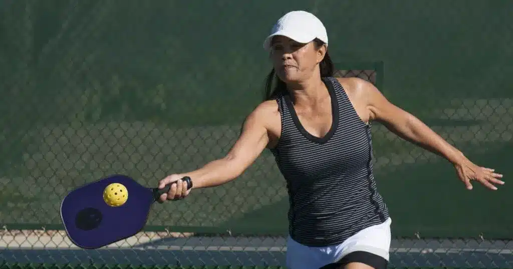 A view of a woman hitting the drive shot in pickleball