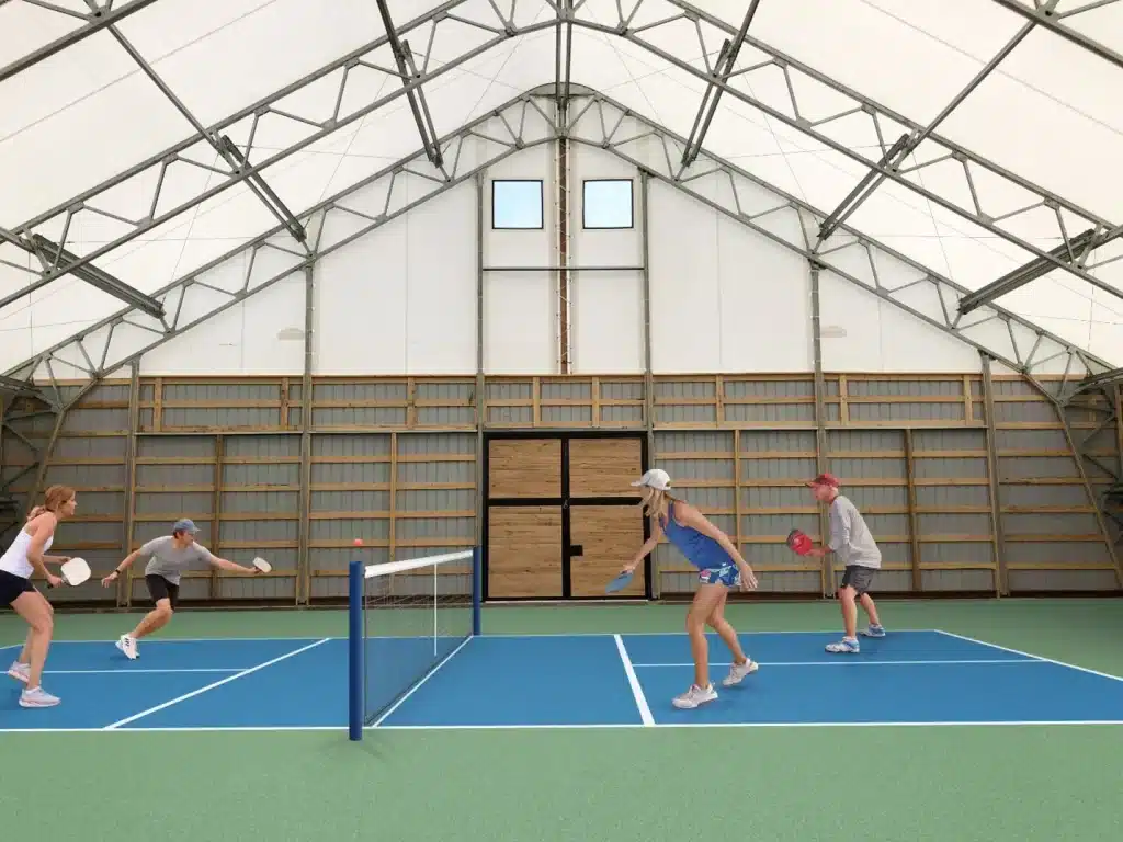 A view of an indoor pickleball court with people playing