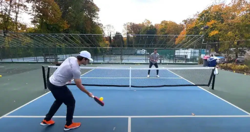 A view of men playing and serving pickleball game strokes