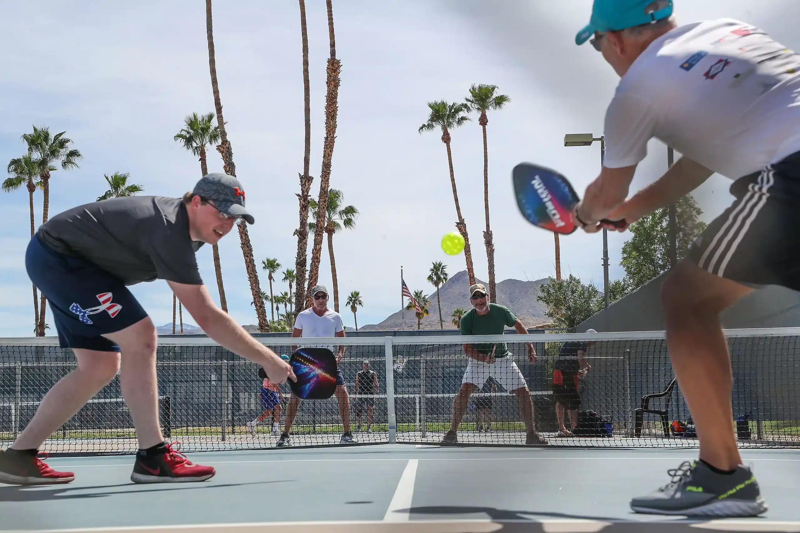 A view of some guys playing pickleball erne shot inside a court