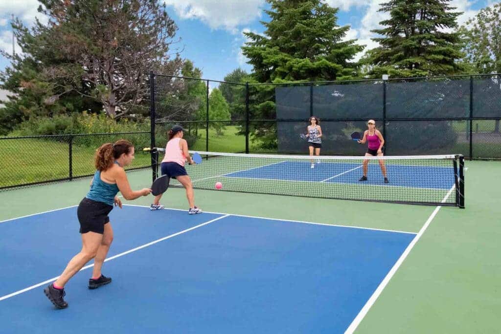 A view of women playing inside a pickleball court