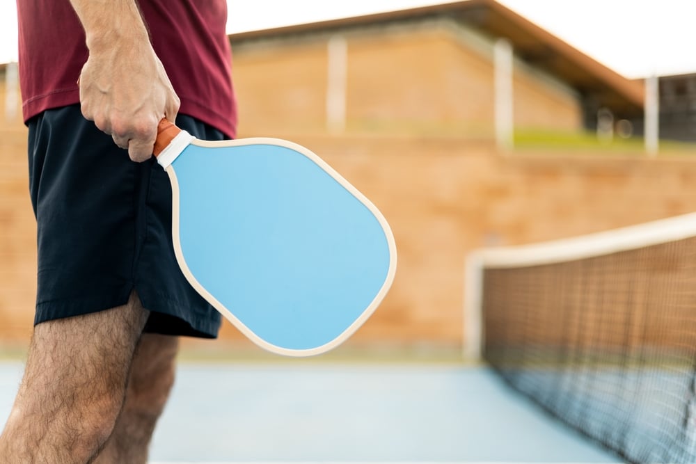 A view of a person holding a pickleball paddle